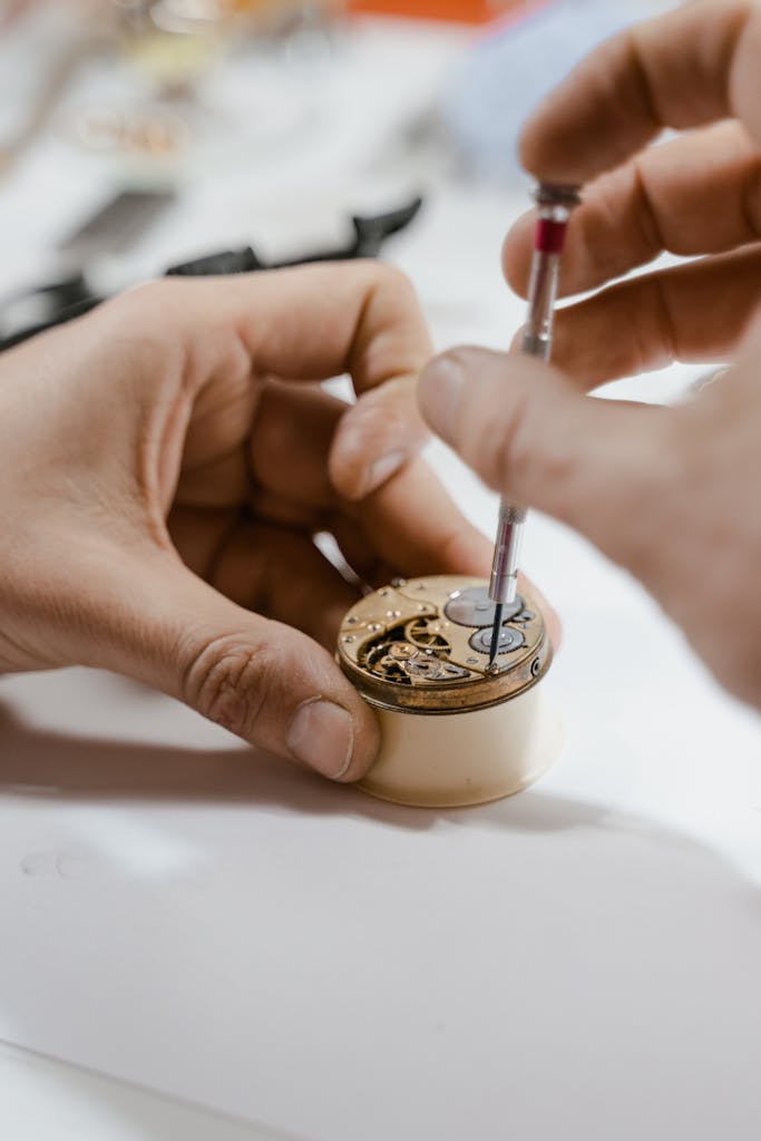 Close-up of a watchmaker delicately repairing a watch mechanism using a precision tool.