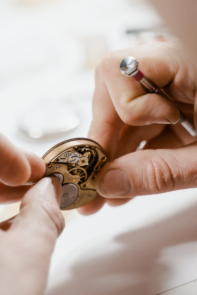 Close-up view of skilled hands repairing a watch with precision tools.